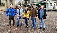 Fünf Personen stehen auf einer noch unbefestigten Fläche im Baustellenbereich vor der Baustelle Vorplatz Altes Rathaus