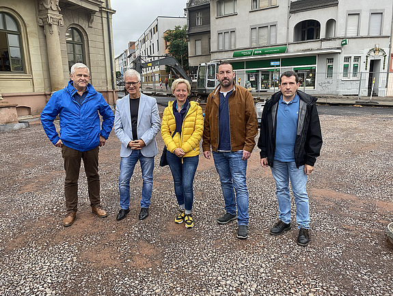 Fünf Personen stehen auf einer noch unbefestigten Fläche im Baustellenbereich vor der Baustelle Vorplatz Altes Rathaus