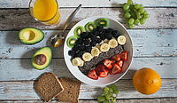 Aufgeschnittene Avocado, Orangensaft, Körnerbrot, Bowl mit Obst