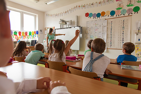 Lehrerin zeigt auf die Tafel