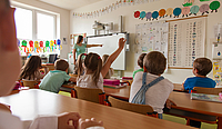 Lehrerin zeigt auf die Tafel