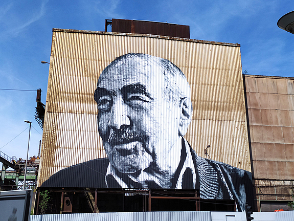 Kunstwerk von Hendrik Beikirch an der Fassade der ehemaligen Stranggussanlage nahe des Bahnhofes