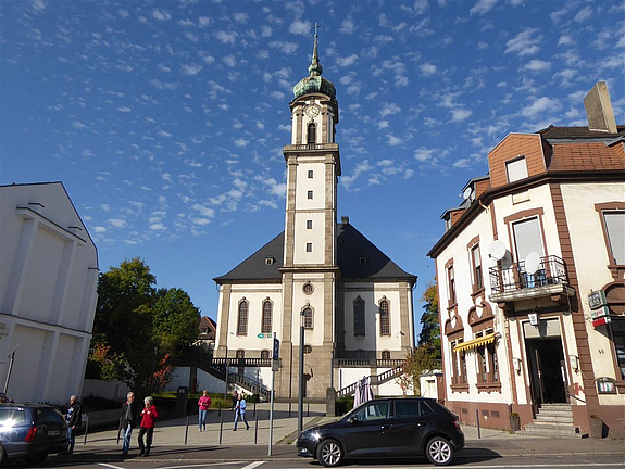 Kirche vor blauem Himmel über den Platz davor gehen Menschen
