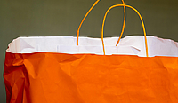 Eine orangefarbene Papiereinkaufstüte