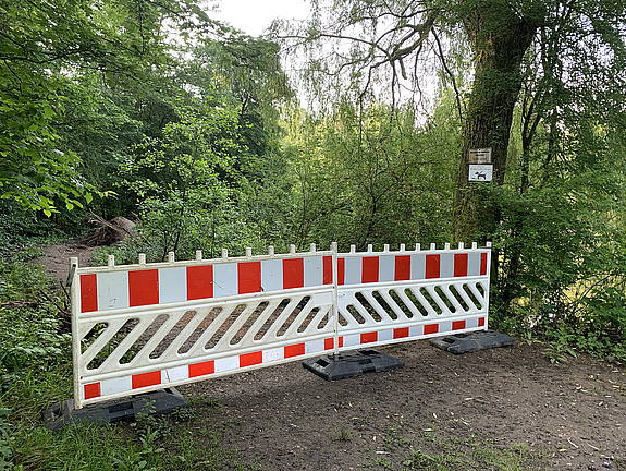Zwei Absperrungsbarken stehen vor dem Zugang zu einem Rundweg im Völklinger Stadtwald.