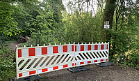 Zwei Absperrungsbarken stehen vor dem Zugang zu einem Rundweg im Völklinger Stadtwald.
