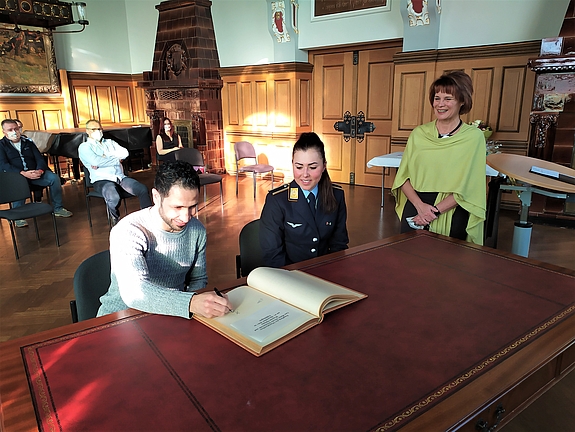 Lisa Klein und Wessam Salamana tragen sich in das Goldene Buch der Stadt Völklingen ein.