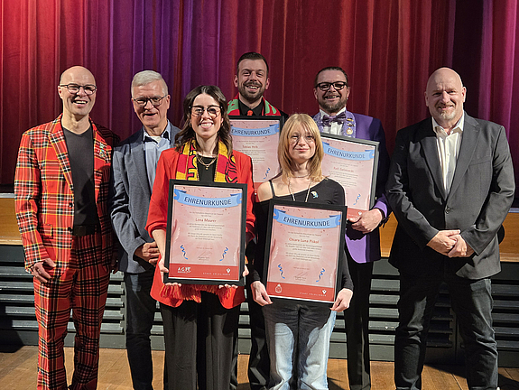 Geehrte und Verwaltung stehen vor der Bühne der Kulturhalle