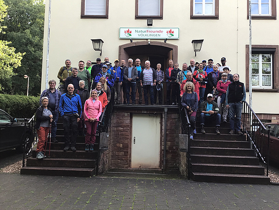 Die Wanderererinnen und Wanderer posieren auf der Treppe vor dem Naturfreundehaus.